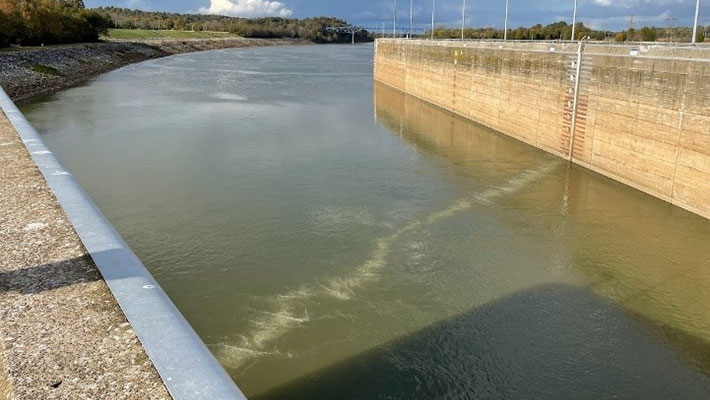 A line of bubbles in the water between the walls of the lock approach.